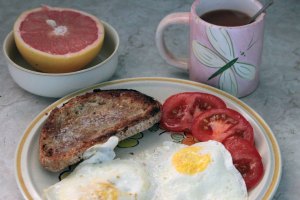 Toast, Eggs Over Hard, Tomato, Grapfruit Half, Tea in a Pink Cup. 